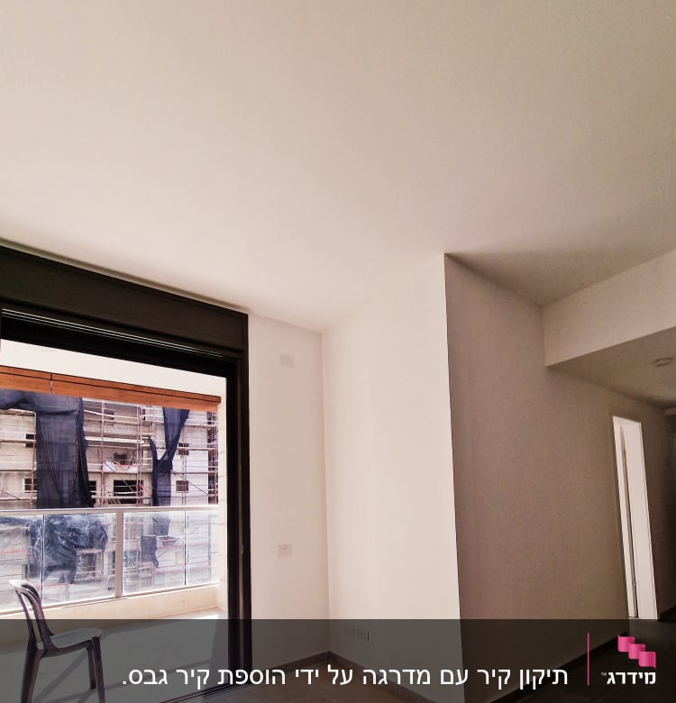 קירות גבס לבנים בחדר עם חלון גדול